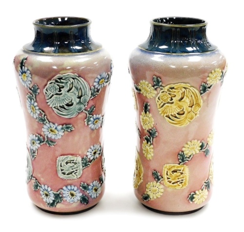 A pair of late 19thC Royal Doulton Lambeth stoneware vases, of cylindrical waisted form, decorated in the Oriental style with Asiatic pheasants, dragons, flowering branches, etc., impressed marks, 23.5cm high.