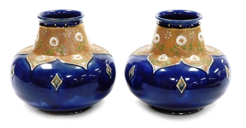 A pair of late 19thC Royal Doulton stoneware vases, each of cylindrical squat form, the raised neck decorated with flowers, the body decorated with diamond motifs against a mottled blue ground, model number 8353, impressed marks, each 15.5cm high.