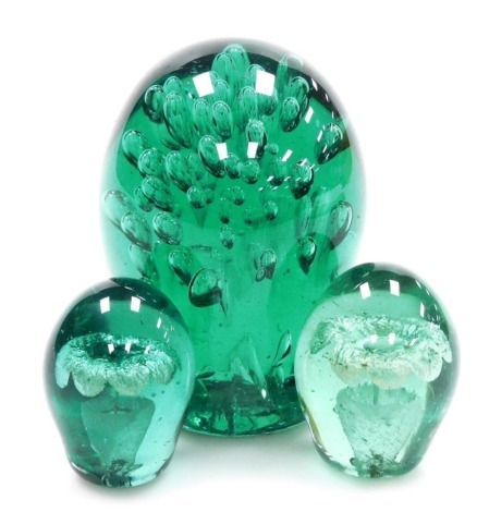 A 19thC green glass dump, with a bubbled interior, 12cm high, together with two further dumps, each with a flowering vase interior, 6cm high.