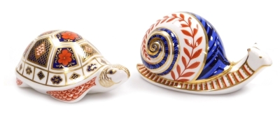 Two Royal Crown Derby porcelain paperweights, seconds, comprising Snail, red printed marks and silver stopper, 12cm high, and Imari Tortoise, red printed marks and silver stopper, 12cm wide.