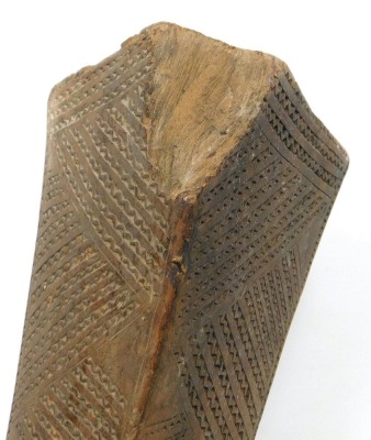 A 19thC Tongan Apa Apai war club, of dense hardwood, the tapering diamond shaped head carved with panels of geometric bands of chevrons, continuing with a plain cylindrical shaft, terminating in a triangular grip with suspension hole, 85cm wide. (AF) - 5