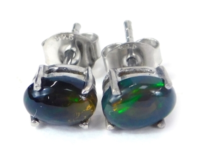 A pair of Ethiopian cabochon black opal stud earrings, each in a basket four claw setting, on single pin back with butterfly backs, white metal stamped 925, 1.3g all in.