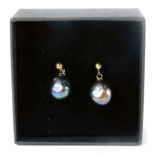 A pair of 9ct gold dark pearl studs, in a black blue/purple ground, on single pin backs with butterfly backs.