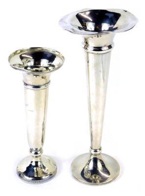 Two Edward VII silver stem vases, one with a fluted, the other with a moulded top, Birmingham 1909, on weighted bases, 23cm and 18cm high, 13.90oz all in. (2)