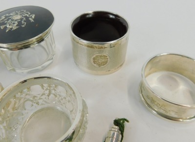 Silver trinkets and effects, comprising three silver napkin rings, one of engine turned design with vacant shield, one bearing initials MYHW, further with Neoclassical scroll border, a tortoiseshell and silver topped dressing table jar, silver rimmed salt - 3