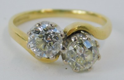 An 18ct gold diamond two stone twist ring, set with two bold cut diamonds, each stone approx 0.87ct, in a platinum claw setting, on a yellow metal band, ring size K½, 4.2g all in, assessed colour H-J, clarity I1/2. - 2