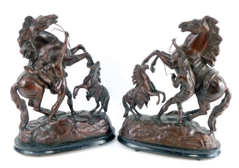 A pair of late 19thC patinated spelter figures of Marley horses, raised on a naturalistic ground and oval wooden ebonised base, 42cm high. (AF)