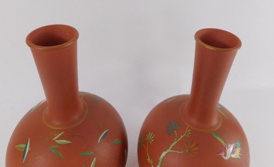 A pair of late 19thC terracotta bottles and lids, enamel decorated with exotic birds, number 9987, 30cm high. - 2