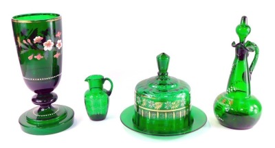 A group of late 19thC green glass, comprising a vase enamel decorated with wild roses, on a knopped stem and stepped circular foot, 32cm high, carafe and stopper, enamel decorated with lily of the valley, 21cm high, cheese dish and cover, enamel decorated