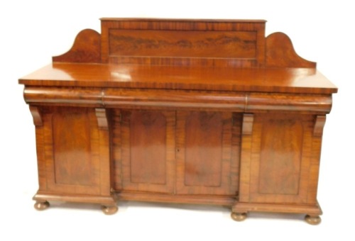 A Victorian flame mahogany breakfront sideboard, with a raised galleried back, and three cushion drawers, an arrangement of four cupboard doors, on bun feet, 132cm high, 188m wide, 64cm deep.