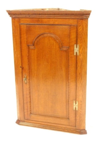 A 19thC oak corner cupboard, with a moulded and fret banded top, with single panel door and brass escutcheon, 104cm high, 66cm wide, 47cm deep.