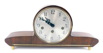 A 1950's German walnut cased mantel clock, circular silvered dial bearing Arabic numerals, eight day movement with Westminster chimes, case of atomic form, raised on four gilt feet, with key, 39cm wide.