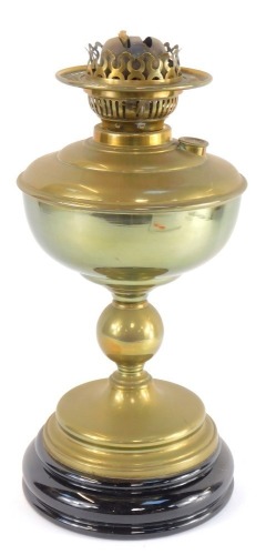 An early 20thC brass oil lamp, lacking chimney and shade, raised on a socle base, 37cm high.