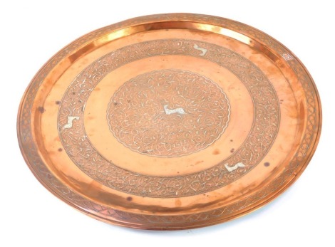 A Middle Eastern copper and damascene silver tray, embossed with leaping deer and foliate scrolls, 45cm wide.