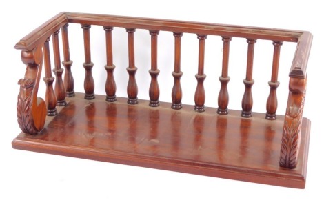 A Librasco mahogany bookshelf, with a galleried back and sides, raised on scroll end supports with leaf carving, raised on a rectangular base, 42cm wide.