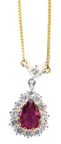 An 18ct gold ruby and diamond pendant and chain, the pendant of tear drop design, set with central pear shaped ruby, surrounded by tiny diamonds, in white gold on a yellow metal fine link chain, the pendant 1.5cm high, the chain 40cm long, 3g all in, boxe