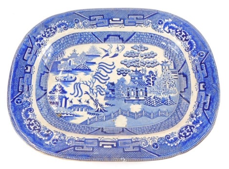 A late 19thC Willow pattern blue and white pottery meat platter, 47cm wide. (AF)