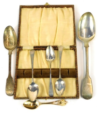 A group of silver spoons, comprising three unmatched Old English pattern teaspoons, and a Victorian silver serving spoon, and a Victorian silver tablespoon, each with eagle crest, London 1865, 5.24oz, and a plated souvenir spoon. (a quantity)