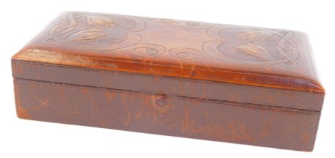 A late 19thC Arts and Crafts tooled leather cigarette box, decorated to the lid with stylised flowers and scrolling tendrils, 18cm wide.