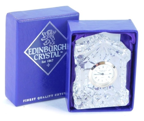 An Edinburgh Crystal miniature clock, circular white dial bearing Roman numerals, quartz movement, the case of architectural form, boxed with guarantee, 6.5cm high, 4.5cm wide.