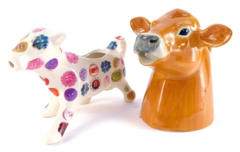 A Quail pottery cream jug modelled as a Jersey cow, number 2010, together with an Avoca Nest pottery cow creamer. (2)