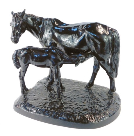 A Soviet mid century cast iron sculpture of a horse and foal, black painted, modelled standing with the foal feeding from its mother, on a naturalistic base, raised mark to base and dated 1952, 36cm wide.