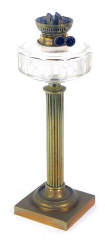 An early 20thC Wright & Butler oil lamp, with brass fluted column support with a glass reservoir, 43cm high.