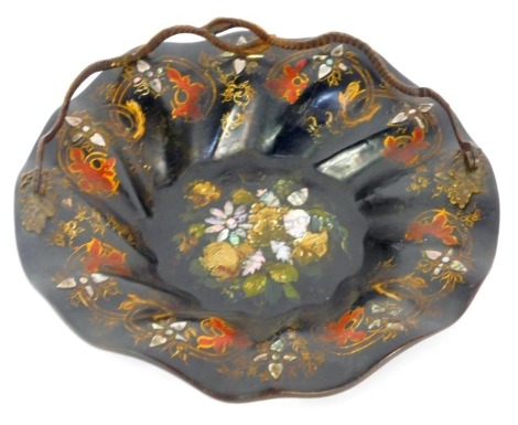 A Victorian papier mache fluted bowl, with painted floral design and mother of pearl inlay, with brass swing handle, 24cm diameter.