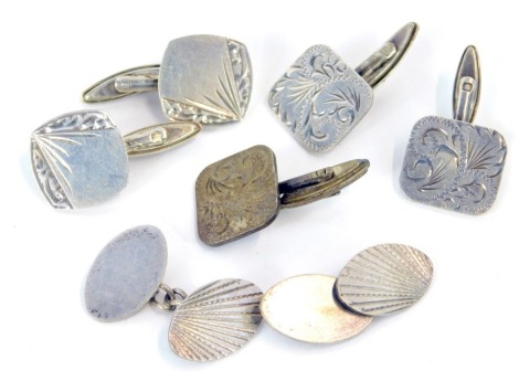 A group of silver cuff links, comprising two pairs of silver floral engraved cuff links, a pair of oval sunburst design cuff links with chain mesh, and a silver silver cuff link of floral scroll design, 36.2g.