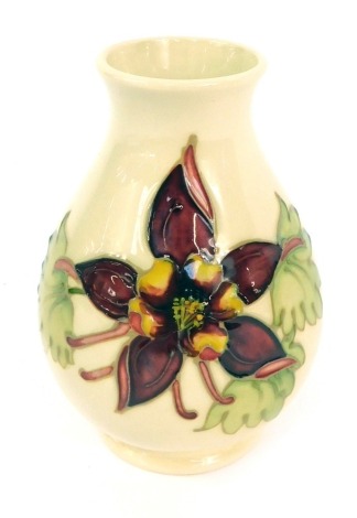 A Moorcroft Pottery vase decorated in the Columbine pattern, impressed and painted marks, 14cm high.