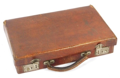 An early 20thC crocodile skin travel case, with a tan leather interior, 36cm wide.