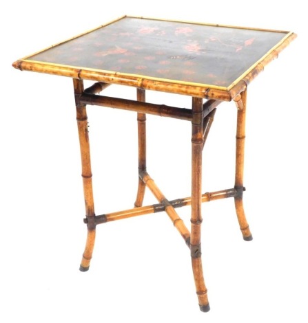 A Victorian Aesthetic Japanned lacquer and bamboo side table, the black lacquer top with red paintings of birds and flowers, on an X framed base with brass cap ends, 69cm high, the top 56cm x 56cm.