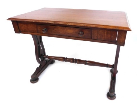 An early Victorian mahogany writing desk, on shaped pierced end supports, on bun feet, united by a turned stretcher, 71cm high, 93cm wide, 55cm deep.