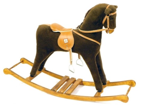 A Mamas and Papas brown rocking horse, brown material horse with tan leather saddle, on a stained pine base, 103cm high, 140cm wide, 40cm deep.