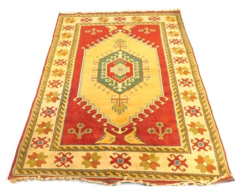 A Turkish rug, 100% wool, with red ground central field and triple borders, with deep cream ground floral border, 250cm x 193cm.