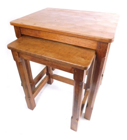 A nest of two 20thC Robert Thompson of Kilburn Mouseman tables, each with adzed tops, on chamfered legs and block feet, with carved mouse to legs, the largest 50cm high, 47cm wide, 36cm deep. (2)