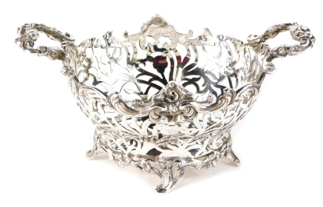 An Edward VII silver basket, by William Comyns, with pierced floral body, and scroll handle, on quadruple scroll feet, London 1904, 11cm high, 10oz.