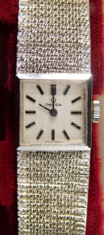 An Omega 9ct white gold cased cocktail watch, with square dial set with baton pointers and numerals, with textured bracelet marked .375, 2cm square face, 26g all in, in outer case.