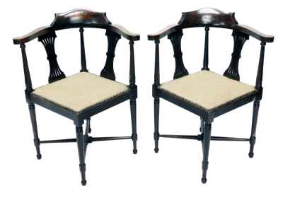 A pair of Edwardian corner chairs, each upholstered in buttoned material, with scroll arms and inverted pierced splats, 78cm high.