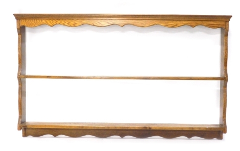 A late 19th/early 20thC oak hanging plate rack, with two shelves, on shaped end supports, 78cm high, 129cm wide.