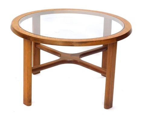 A G-Plan style teak circular coffee table, with smoked glass top and X shaped support, 71cm diameter.