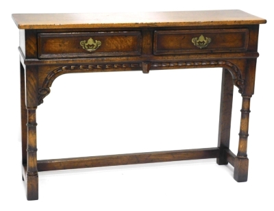 An oak small dresser or side table, in 18thC style, the rectangular top above two frieze drawers and a carved frieze, on turned supports with low stretcher, possibly Titchmarsh and Goodwin, 76cm high, 107cm wide, 30cm deep.