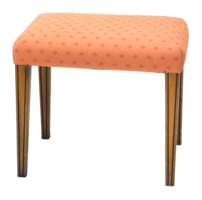 A walnut stool, with a padded seat, on channelled square tapering legs, 52cm wide. The upholstery in this lot does not comply with the 1988 (Fire & Fire Furnishing) Regulations, unless sold to a known exporter or upholsterer it will be cut from the frame