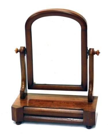 A Victorian mahogany table mirror, with arched glass flanked by scroll support, on an inverted platform, with cushion front drawer on compressed bun feet, 58cm high.