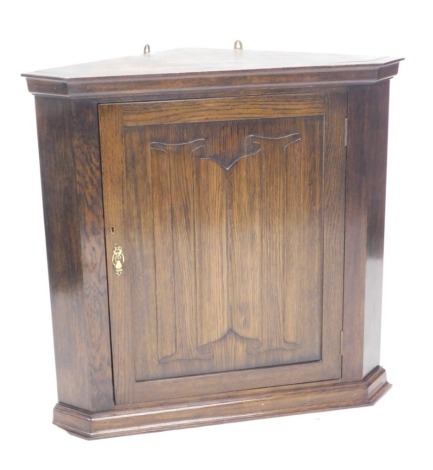 An oak corner cabinet, with linenfold carved panelled door, 86cm high, 89cm wide.