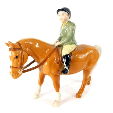 A Beswick pottery figure, boy on palomino pony, green jacket, printed marks beneath, 12cm high.