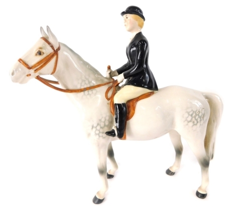 A Beswick pottery black jacketed huntswoman, on grey horse, printed marks beneath, 21cm high.