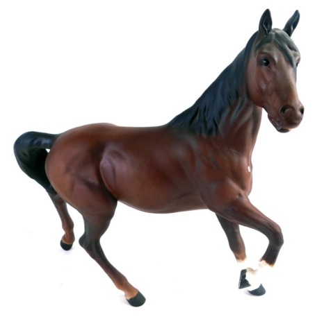 A Beswick matt finish pottery figure of a cantering horse, right leg raised, printed marks beneath, 21cm high.