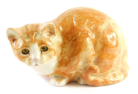 A 20thC Winstanley style pottery figure of a ginger cat, with glass eyes, unmarked, 14cm high.