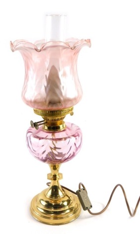 A 20thC oil lamp, with amethyst coloured shade and reservoir, with brass stem, dials marked duplex, with modern electrical feature, 46cm high.